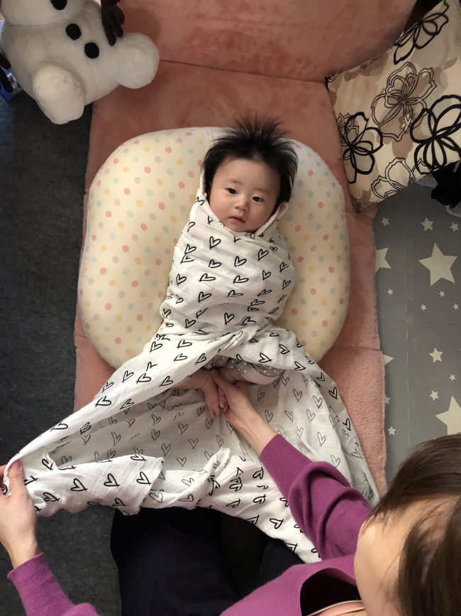 足は少し曲げて軽く抑えてあげます。 足元の端を持って…