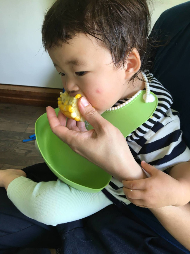 近所の畑でとれたとうもろこしにかぶりつく娘。とれたてのとうもろこしは身がプリプリしていておいしいです