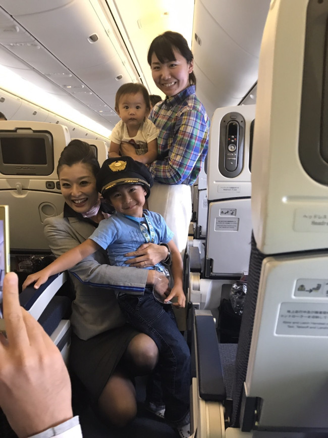 機長さんの帽子をかぶってパチリ。飛行機での旅行が、家族みんなの楽しい思い出になるといいですね