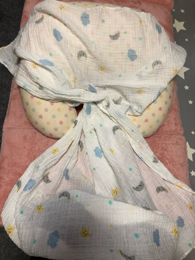 おくるみを縦長に置き、真ん中をクロスさせます