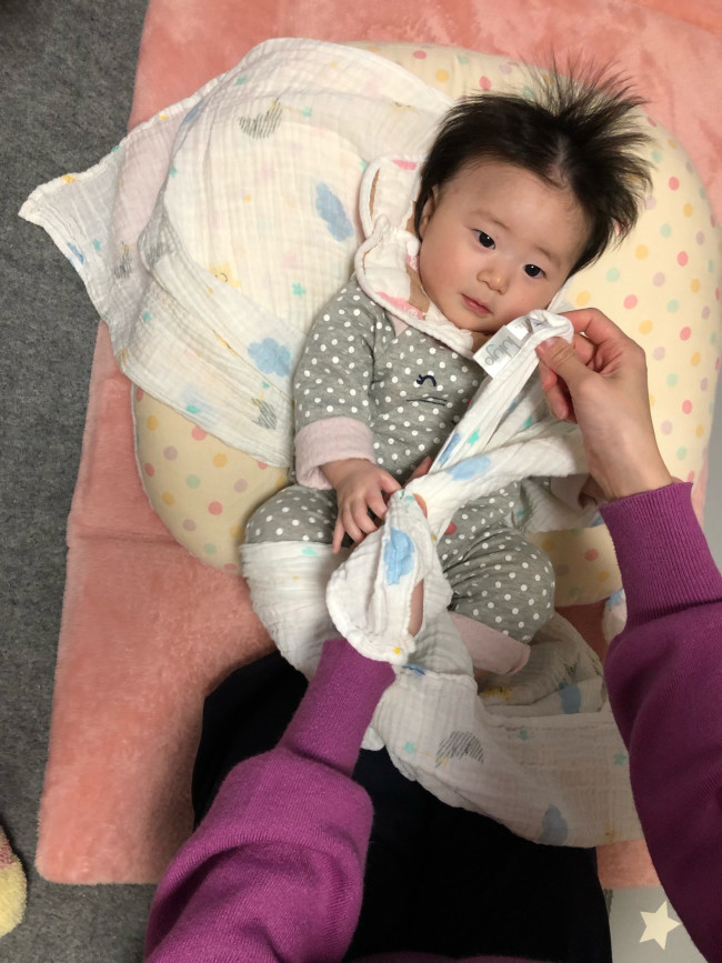 肩側の端と、対角線上の端を、赤ちゃんのお尻をすっぽり包み込むような形で結びます